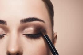 Woman putting on eye makeup